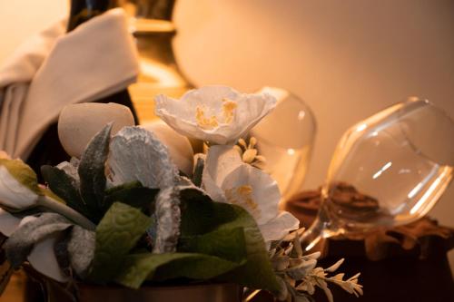 a vase with flowers on a table next to a wine glass at Maison Cly in Chamois