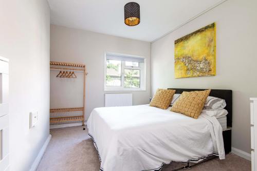 a bedroom with a white bed with yellow pillows at One bedroom apartment in London
