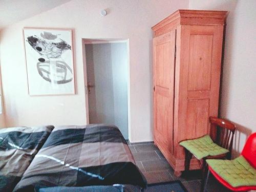 um quarto com uma cama e um armário de madeira em Zelfies Kunstapartment. em Nonnweiler