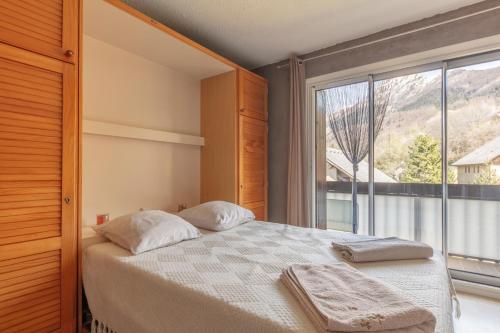 une chambre avec un lit et une grande fenêtre dans l'établissement Le Skieur, à Saint-Léger-les-Mélèzes