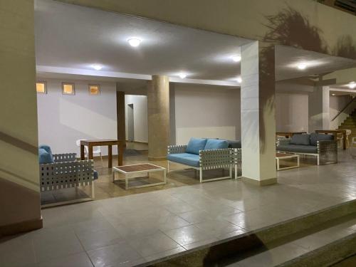 a waiting room with blue couches and a table at Playa Azul Suites in Tonsupa