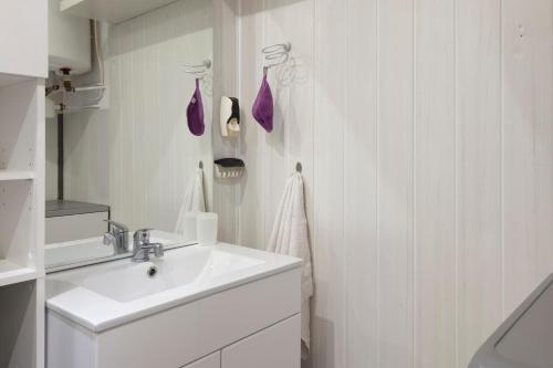 une salle de bain blanche avec un lavabo et un miroir dans l'établissement Le Skieur, à Saint-Léger-les-Mélèzes