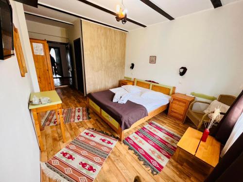 a small bedroom with a bed and a couch at Pensiunea Casa Boiereasca in Peştera