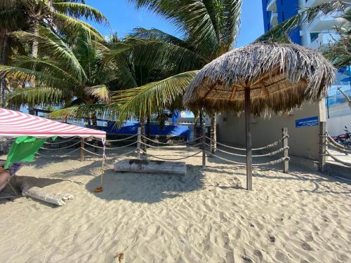 a beach with two umbrellas on the sand at Playa Azul Suites in Tonsupa