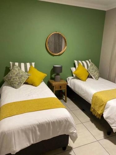 a room with two beds and a mirror on the wall at Gable Cottages No.4 Clarens in Clarens