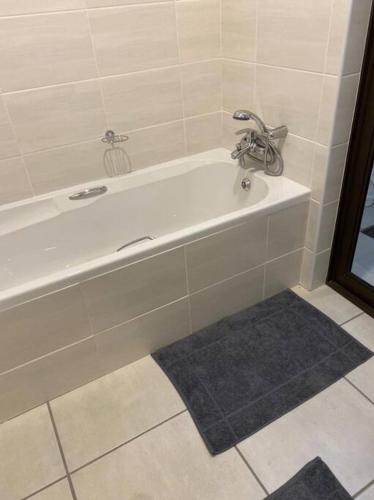 a white bath tub with a faucet in a bathroom at Gable Cottages No.4 Clarens in Clarens