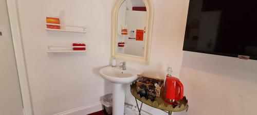 a white bathroom with a sink and a mirror at Holly Cottages in Bowness-on-Windermere