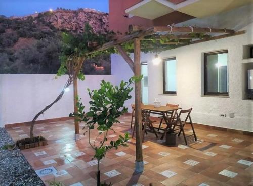 um quarto com uma mesa e uma mesa e uma árvore em Dimora d'Estate (Sicilian Holidays) em Milazzo