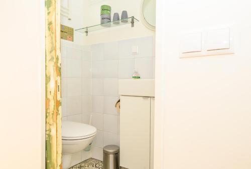 Un baño pequeño con inodoro y lavabo. en Houseboat studio with canalview and free bikes, en Ámsterdam