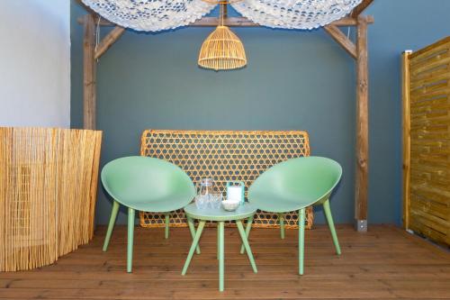 two chairs and a table in a room at Idylle - Charmant bungalow à 2 pas du lagon in La Saline les Bains