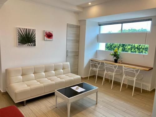a living room with a couch and a table at Playa Azul Suites in Tonsupa