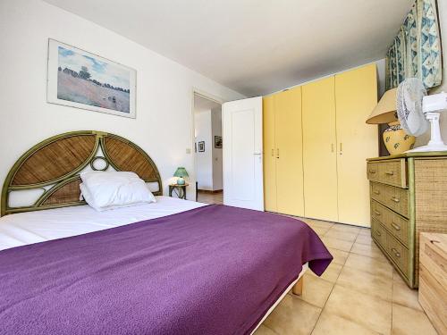 - une chambre avec un grand lit violet et des armoires jaunes dans l'établissement Palais Rouaze 2P SOM2151, à Cannes