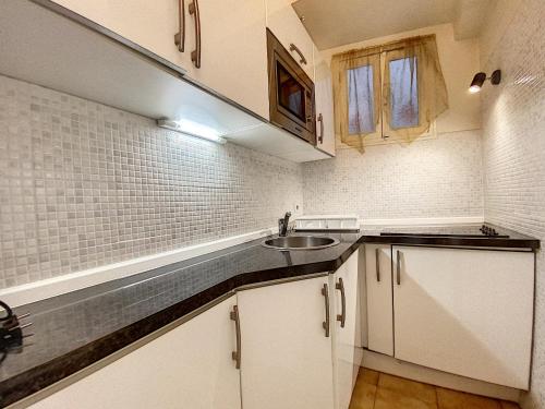 une petite cuisine avec des armoires blanches et un évier dans l'établissement Palais Rouaze 2P SOM2151, à Cannes