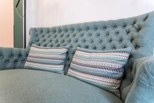 a blue couch with two pillows on it at Casas da Formosa - Downtown Alegria in Tavira