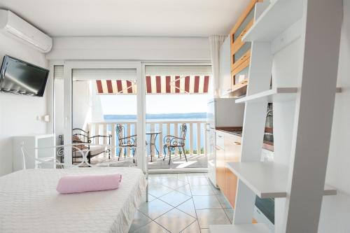 a bedroom with a bed and a balcony at Apartments Gordana in Lokva Rogoznica