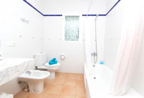 ein weißes Bad mit einem WC und einer Dusche in der Unterkunft Villa Belinda by Sonne Villas in Es Migjorn Gran