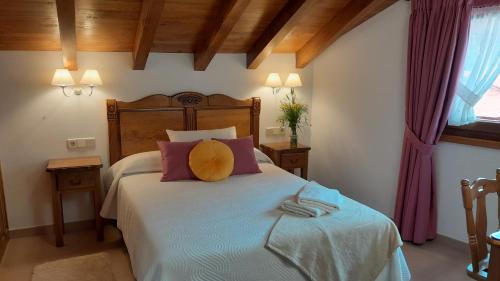 Schlafzimmer mit einem großen Bett mit einem Kopfteil aus Holz in der Unterkunft Apartamentos El Haya in Cosgaya