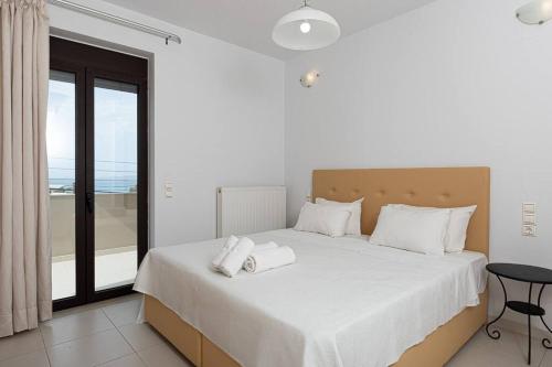 1 dormitorio con 1 cama blanca grande con almohadas blancas en Casa di Brillanti, 2min from the beach! en Karteros