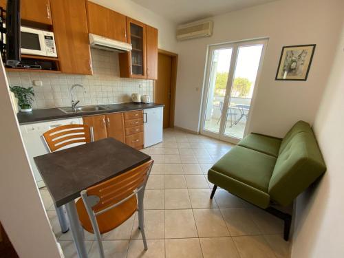 een kleine keuken met een tafel en een groene stoel bij Apartment in Punat with Terrace, Air conditioning, Wifi, Washing machine (3829-3) in Punat