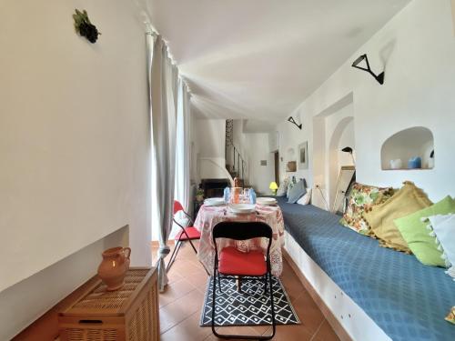 Habitación con cama, mesa y sillas. en holidaycasa Piki - Panoramico a mare, en Sperlonga
