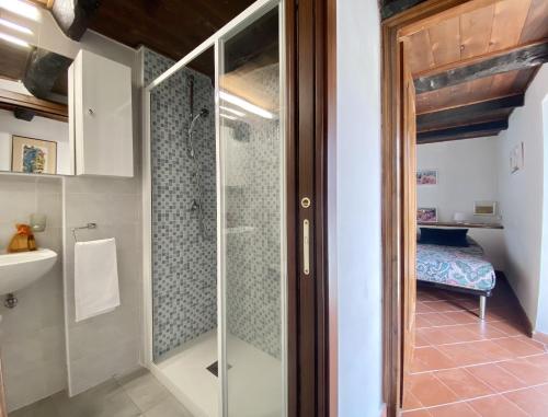スペルロンガにあるholidaycasa Piki - Panoramico a mareのバスルーム(ガラス張りのシャワー、シンク付)