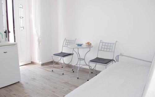a kitchen with two chairs and a table in a room at Marea Apartments in Symi