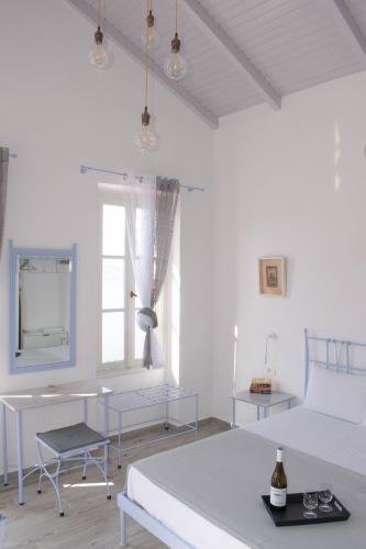a white room with a table and a couch at Marea Apartments in Symi