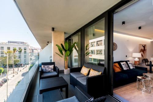 uma sala de estar com um sofá na varanda em Apartmentsole - San Pablo em Sevilha