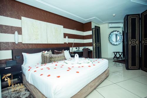 a bedroom with a large bed with red flowers on it at Oak Plaza Hotels East Airport in Accra