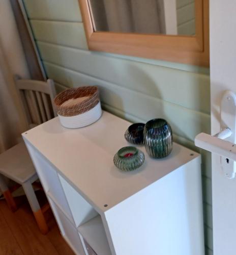 einen kleinen weißen Tisch mit zwei Vasen drauf in der Unterkunft Le Numéro 12 - Chalet à Francorchamps in Malmedy