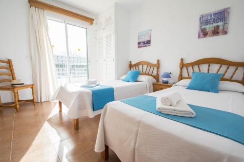 a bedroom with two beds and a large window at Miramar L by Sonne Villas in Cala Galdana