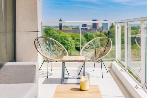 twee stoelen op een balkon met een kaars bij SHS HOMES-LUXE HIGHRISE, 2 BEDROOMS, KITCHEN, FREE PARKING, STUNNING VIEW, LARGE TARRASSE, Workspace in Hasselt