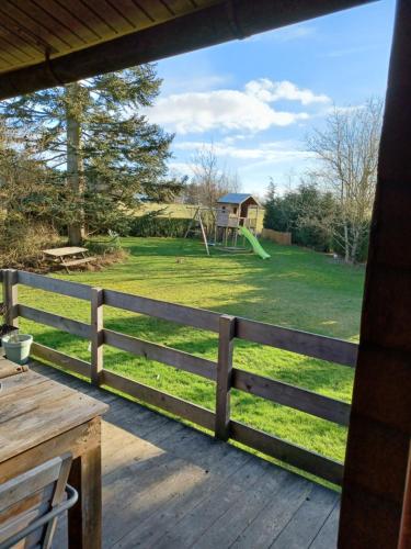 eine Veranda mit einem Zaun und einem Spielplatz in der Unterkunft Le Numéro 12 - Chalet à Francorchamps in Malmedy