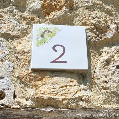 a sign with the number two on a stone wall at Agriturismo Monte Gusciani in Massa Marittima