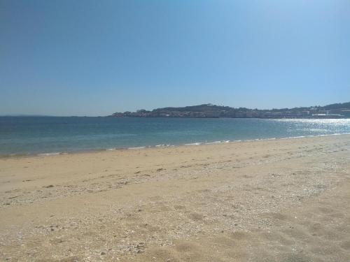 a sandy beach with the ocean in the background at En Ribeira para 4 céntrico con parking in Ribeira