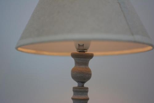a lamp with a white lamp shade on a table at Cozy Centrale in Tinos Town