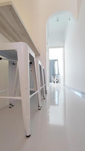 a white hallway with white stairs in a room at Cozy Centrale in Tinos Town