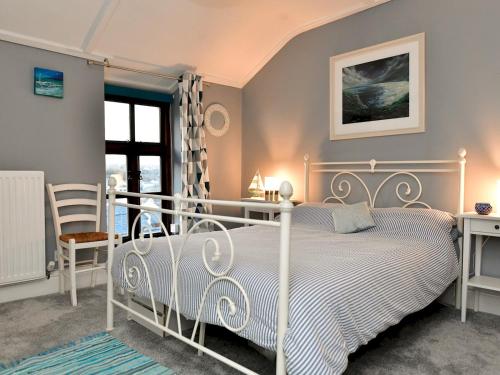Schlafzimmer mit einem weißen Bett und einem Schreibtisch in der Unterkunft Pass the Keys Charming Fisherman's cottage with stunning sea views in Swansea