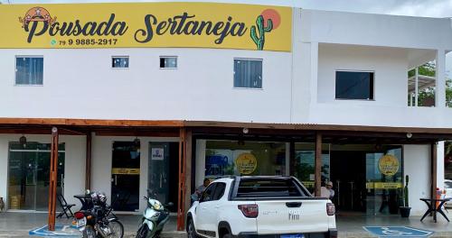 a white truck parked in front of a store at Pousada Sertaneja in Canindé de São Francisco