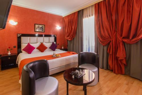 Habitación de hotel con cama, mesa y sillas en Hotel Meriem Marrakech en Marrakech
