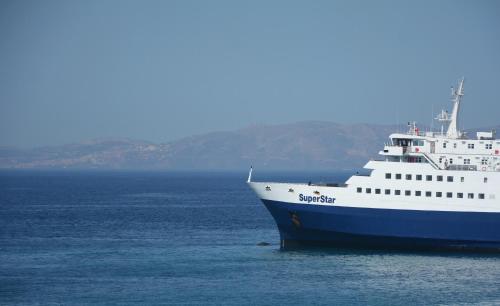a large cruise ship sitting in the water at Cozy Centrale in Tinos Town
