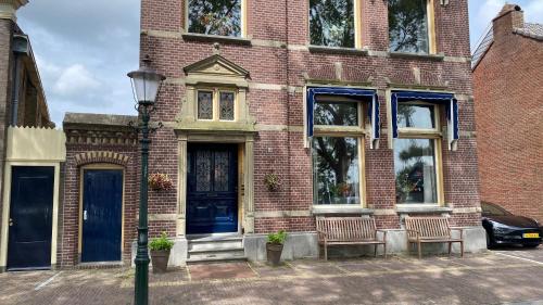 a brick house with two chairs in front of it at BNB In het centrum van Enkhuizen in Enkhuizen