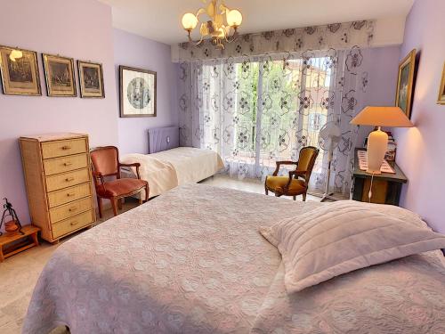 une chambre avec un lit, une commode et une fenêtre dans l'établissement Le Windsor 2P DET2002, à Cannes