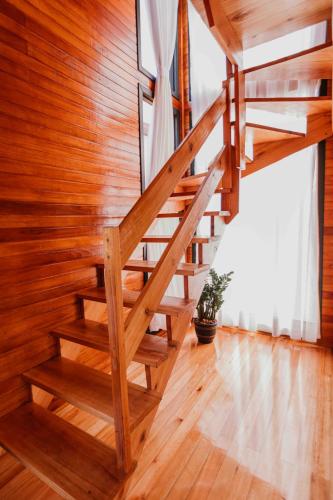 a wooden staircase in a room with wood walls at Capanna del Vale - Refúgio & Degustação no Vale dos Vinhedos in Bento Gonçalves