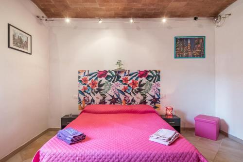 a bedroom with a pink bed with a colorful headboard at Borgo Rosia 85 in Rosia
