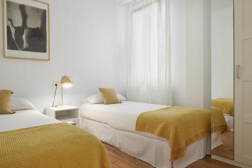 a bedroom with two beds with yellow blankets at Always Easy I Kursaal in San Sebastián