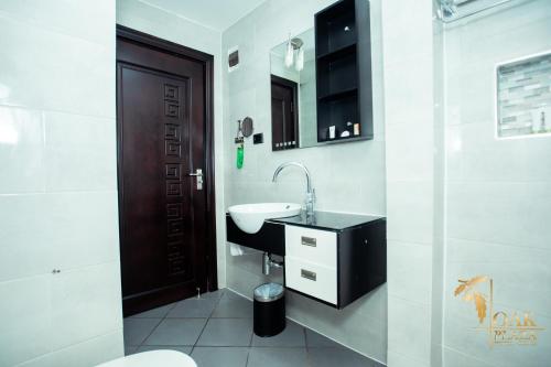 a bathroom with a sink and a toilet at Oak Plaza Hotels East Airport in Accra
