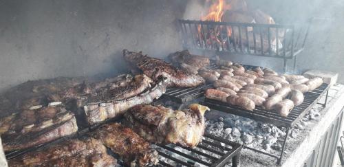 a bunch of meat and other food on a grill at Base Manzano in Tunuyán