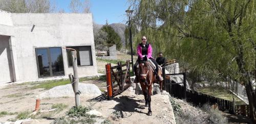 a woman riding a horse down a fence at Base Manzano in Tunuyán