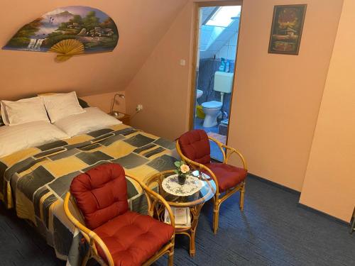 1 dormitorio con 1 cama, 2 sillas y mesa en Zsoli Vendégház, en Alsópáhok